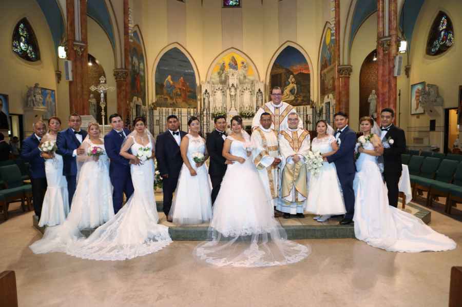 A wedding party posing for a picture in a church.