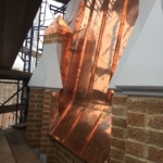 A copper roof is being installed on a building.
