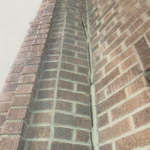 A brick wall with a crack in it.
