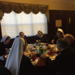 A group of nuns sitting around a table.