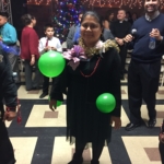 A woman holding a green balloon.