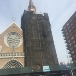 A church with a steeple and scaffolding in front of it.