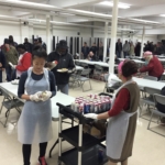 A group of people preparing food in a large room.
