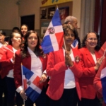 A group of people in red jackets holding flags.
