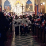 A group of people standing in a church with flags.