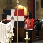 A woman holding a dominican flag in a church.