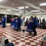 A group of people dancing in a room.