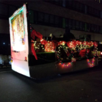 A float decorated with christmas lights on a street.