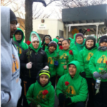 A group of people in green hoodies posing for a photo.