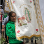 A woman holding a banner with the image of the virgin of guadalupe.