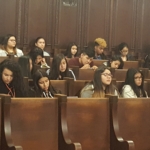 A group of people sitting in a courtroom.