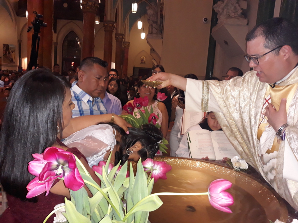 A priest pouring water into a bowl of flowers.
