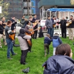 A group of people playing music on a grassy area.