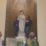 A group of people looking at a statue in a church.
