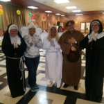 A group of people dressed as nuns in a room.