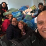 A group of people posing for a selfie in a room full of plastic bags.