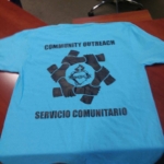 A blue t - shirt with the words community outreach on it.