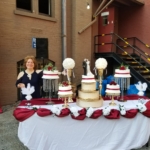 A woman standing in front of a cake table.