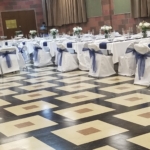 A room with tables and chairs set up for a wedding.