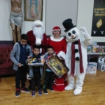 Santa claus and santa claus posing with children.