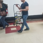 A man pushing a shopping cart full of groceries.