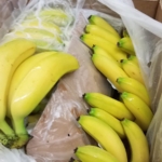 A box of bananas sitting on a table.