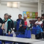 A group of people standing in line at a cafeteria.