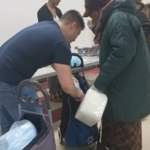 A group of people helping a woman with her luggage.