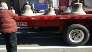 A red trailer with bells on the back of it.