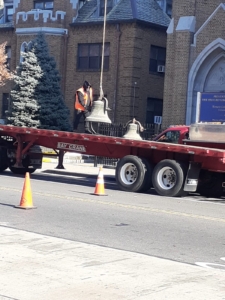 A red flatbed truck with two men on it.