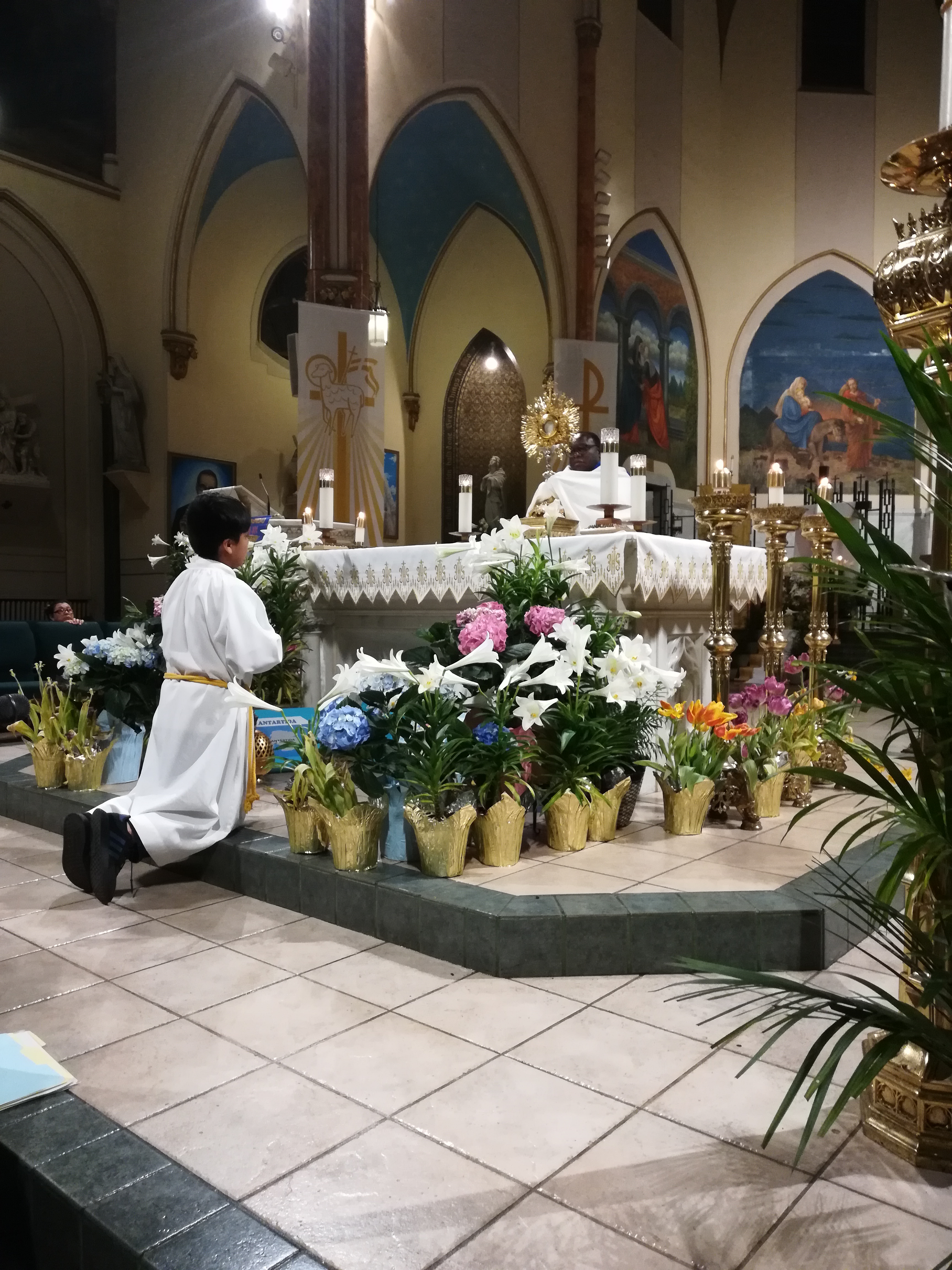A person kneeling down in front of a church altar.