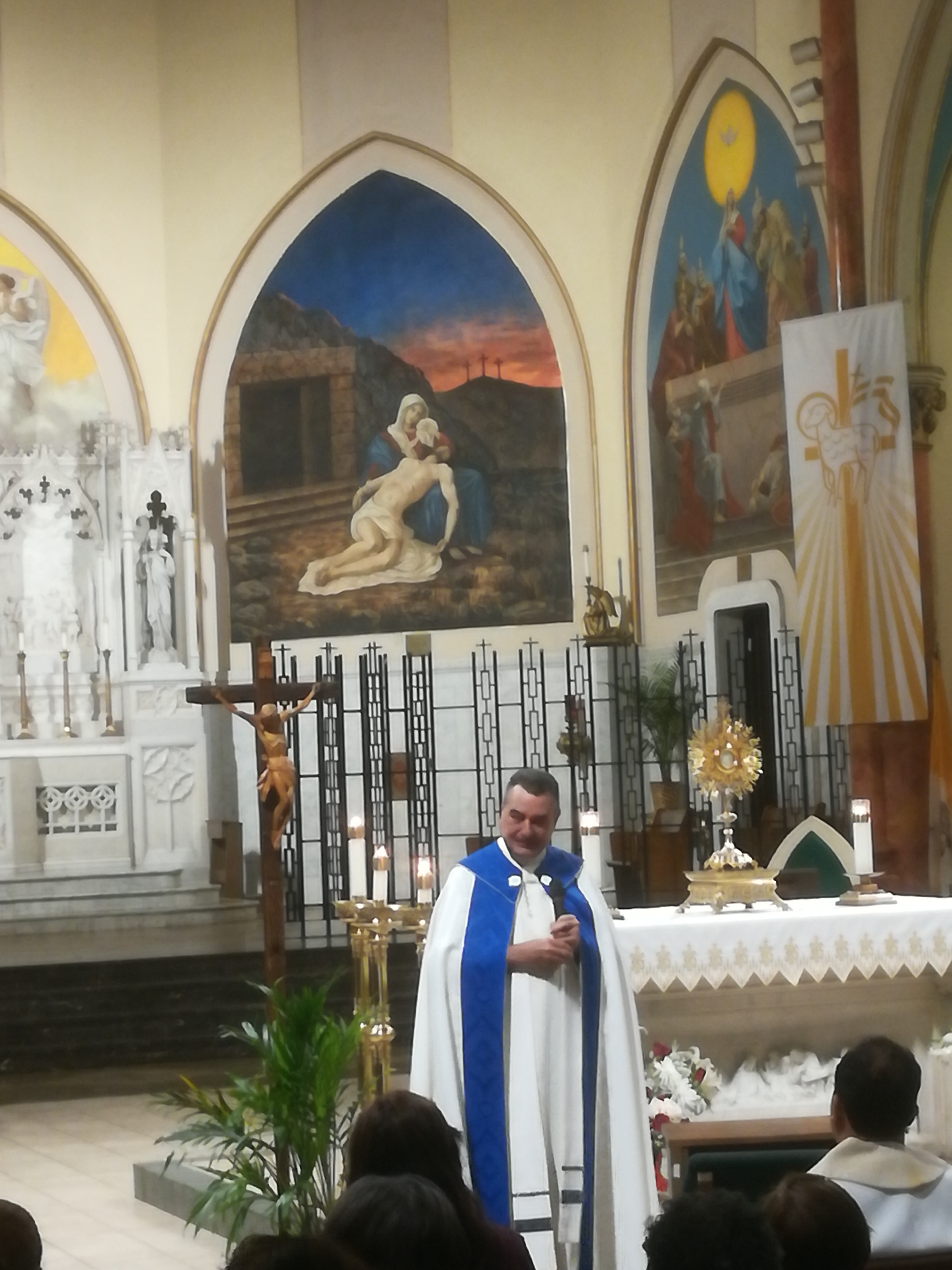 A priest standing in front of a church altar.