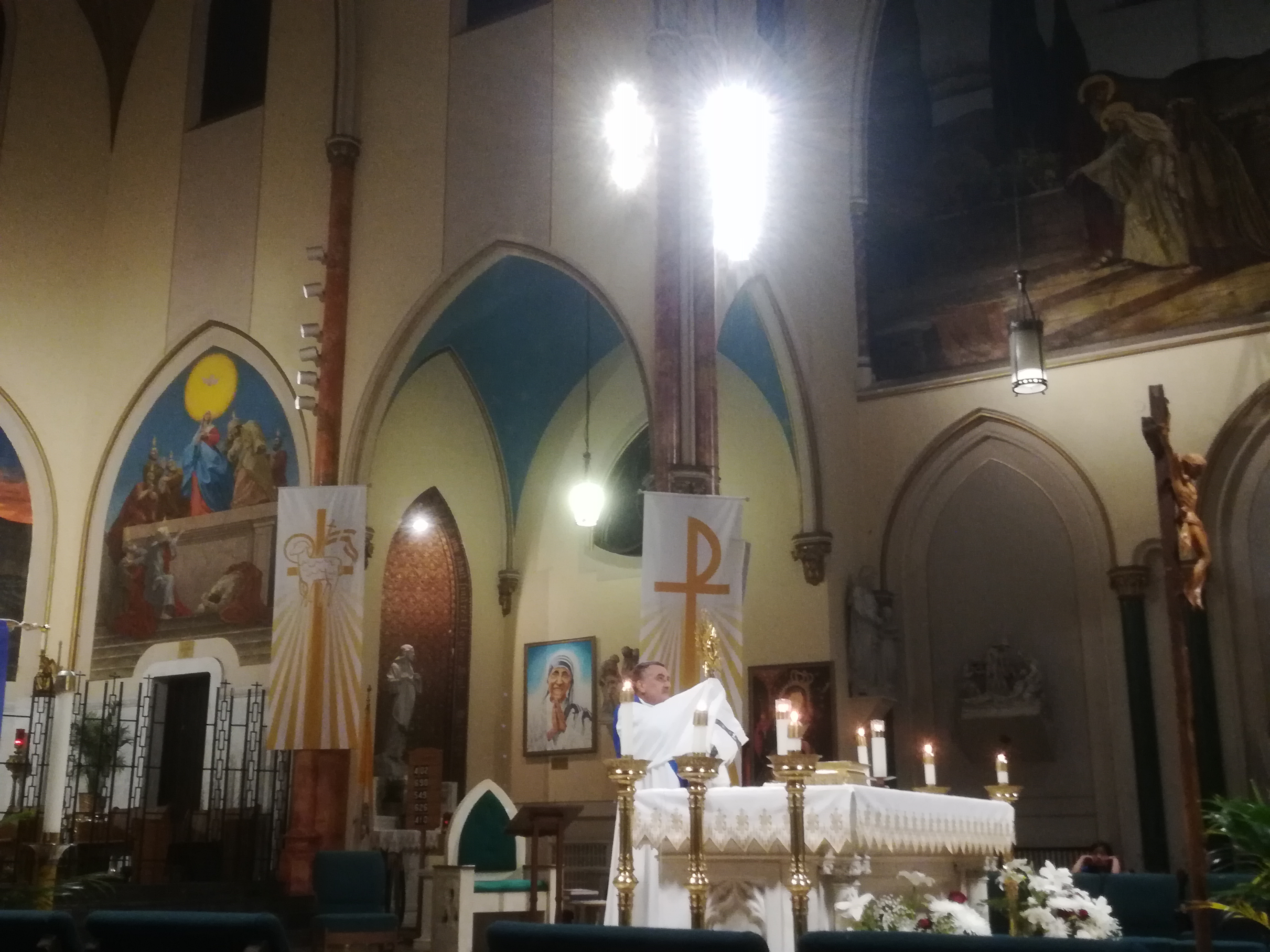 A priest is standing in front of the altar.