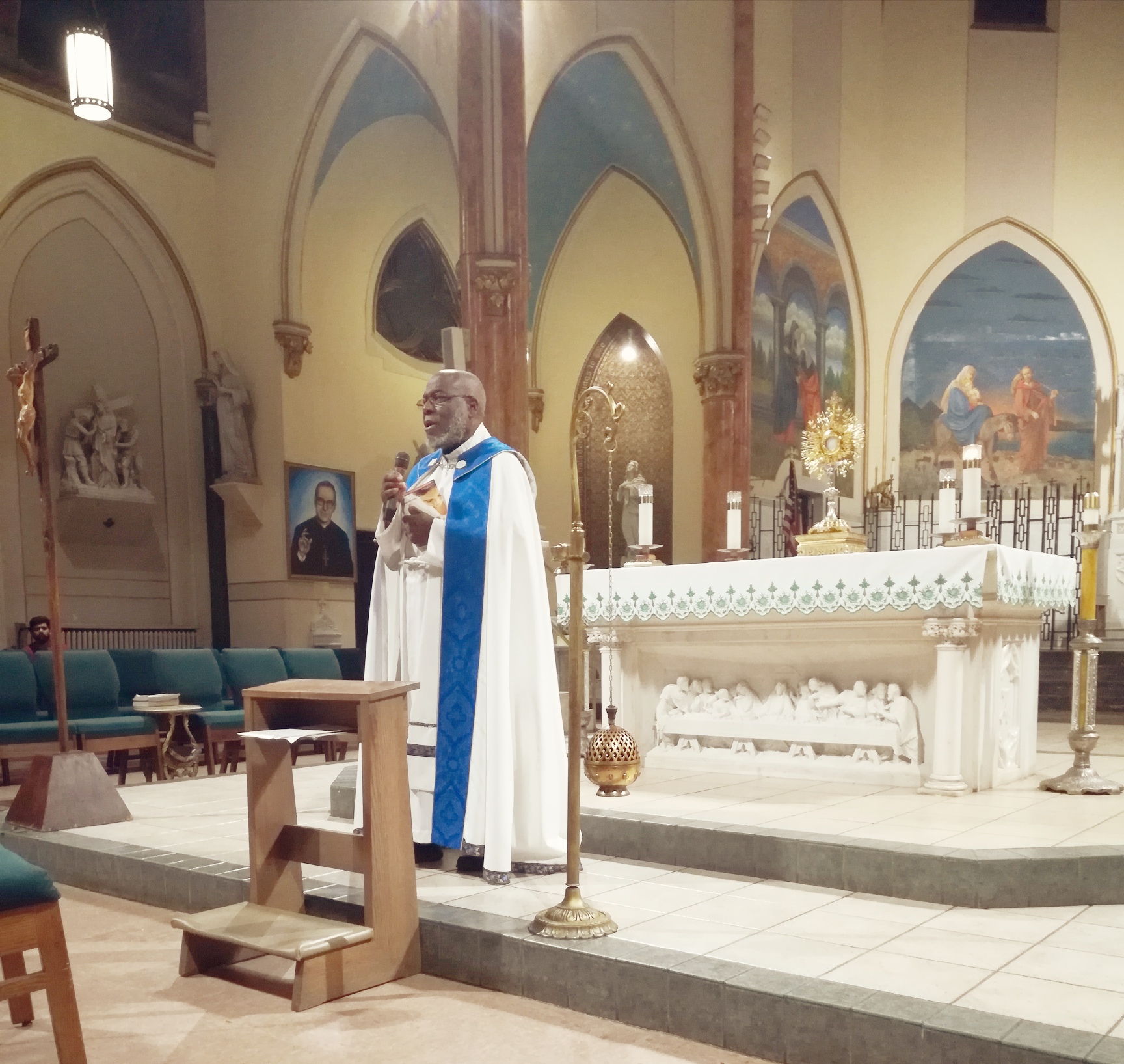 A priest standing in front of a pulpit in a church.