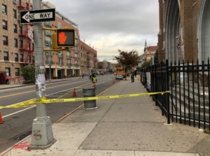A street with yellow tape blocking off the sidewalk.