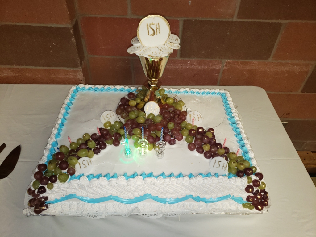 A cake with grapes and a candle on it