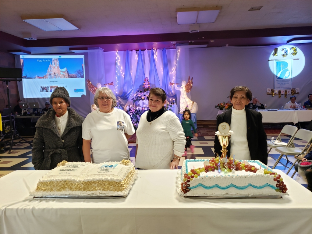 A group of people standing around some cakes