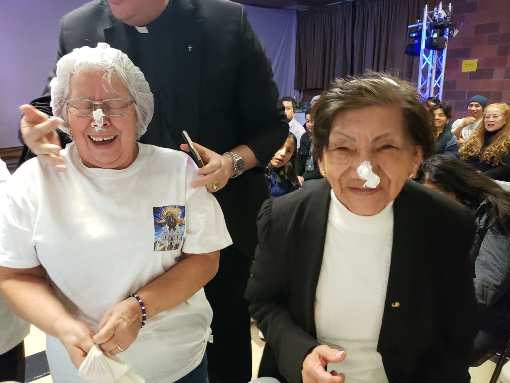 Two women with their mouths open and one of them is smiling.
