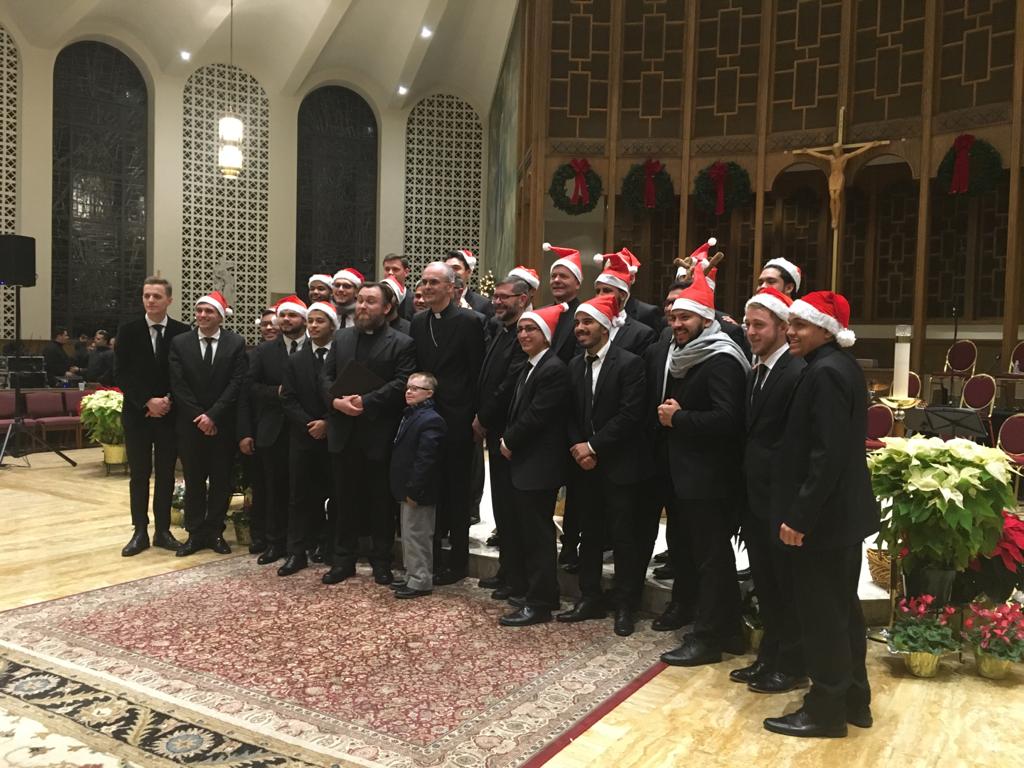 A group of men in suits and santa hats.