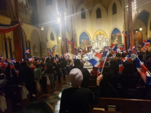 A crowd of people in a church with flags.