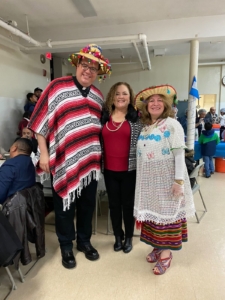 Three people in mexican costumes posing for a picture.