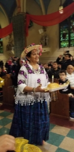 A woman in traditional mexican dress holding food.