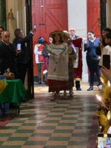 A woman in traditional mexican dress walking down the hall way.