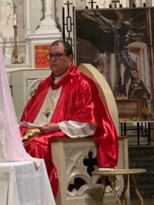 A priest sitting in front of the altar.