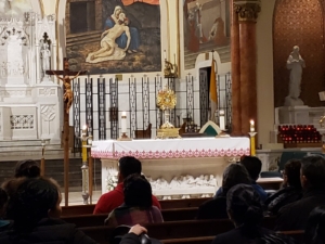A group of people sitting in front of a church altar.