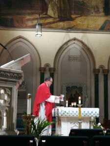 A man in red is standing at the altar