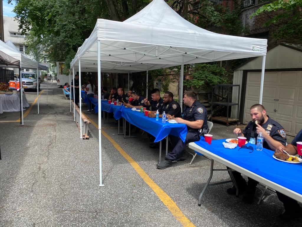 A group of police officers sitting at tables under a tent.