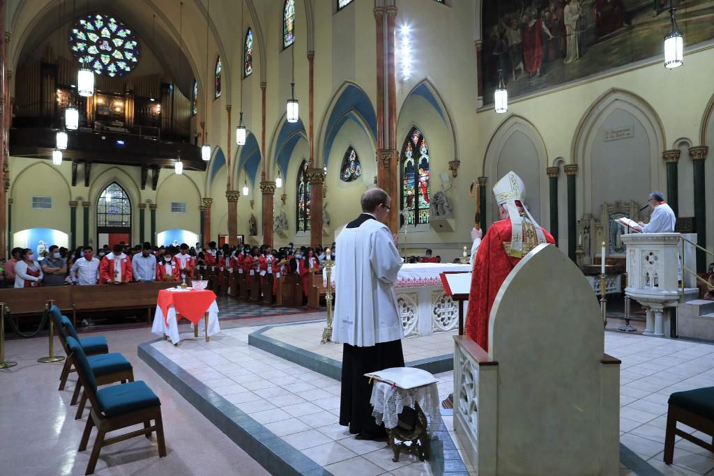A priest is standing in front of the altar.