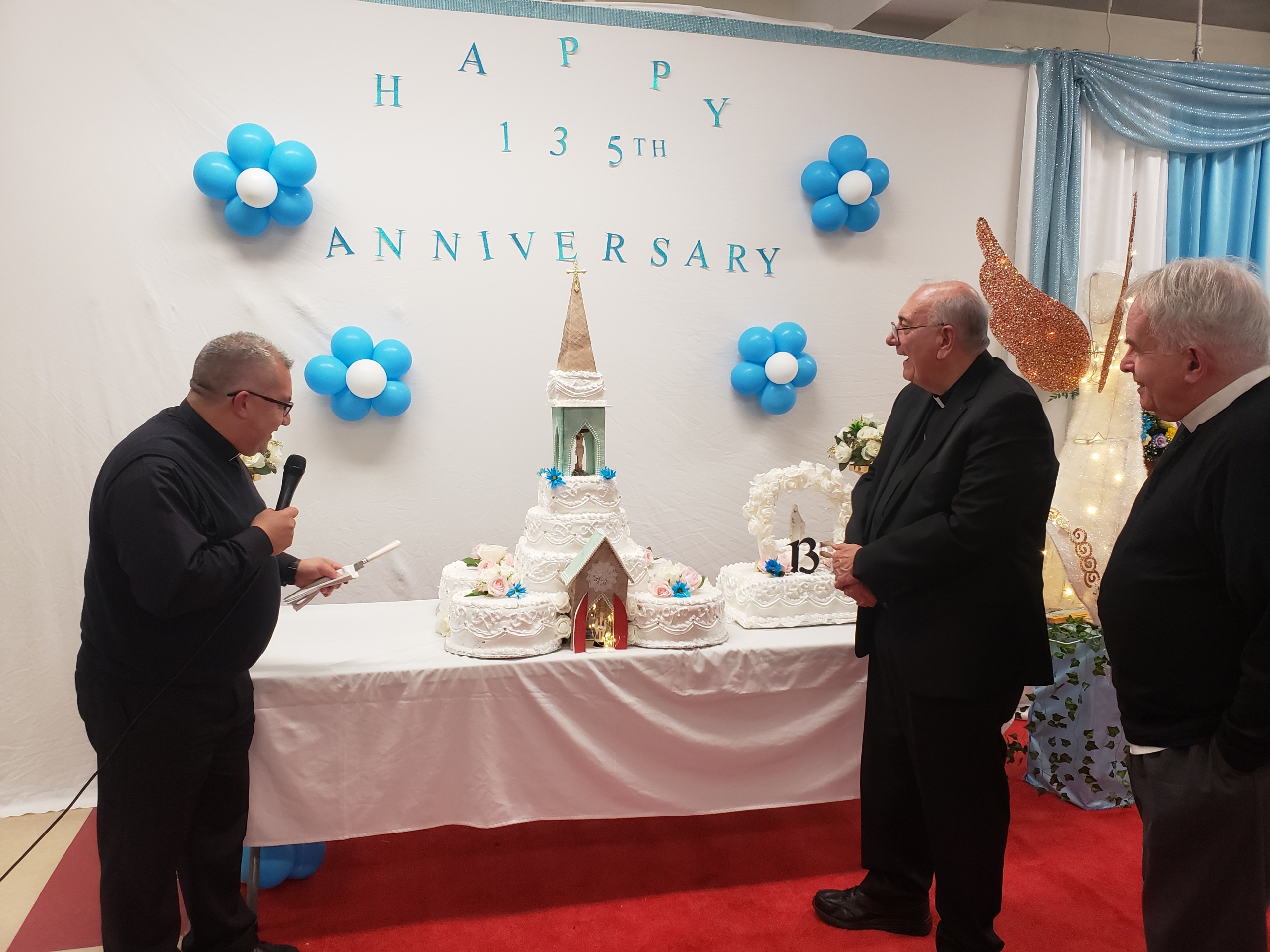 Two men standing in front of a table with cake on it.