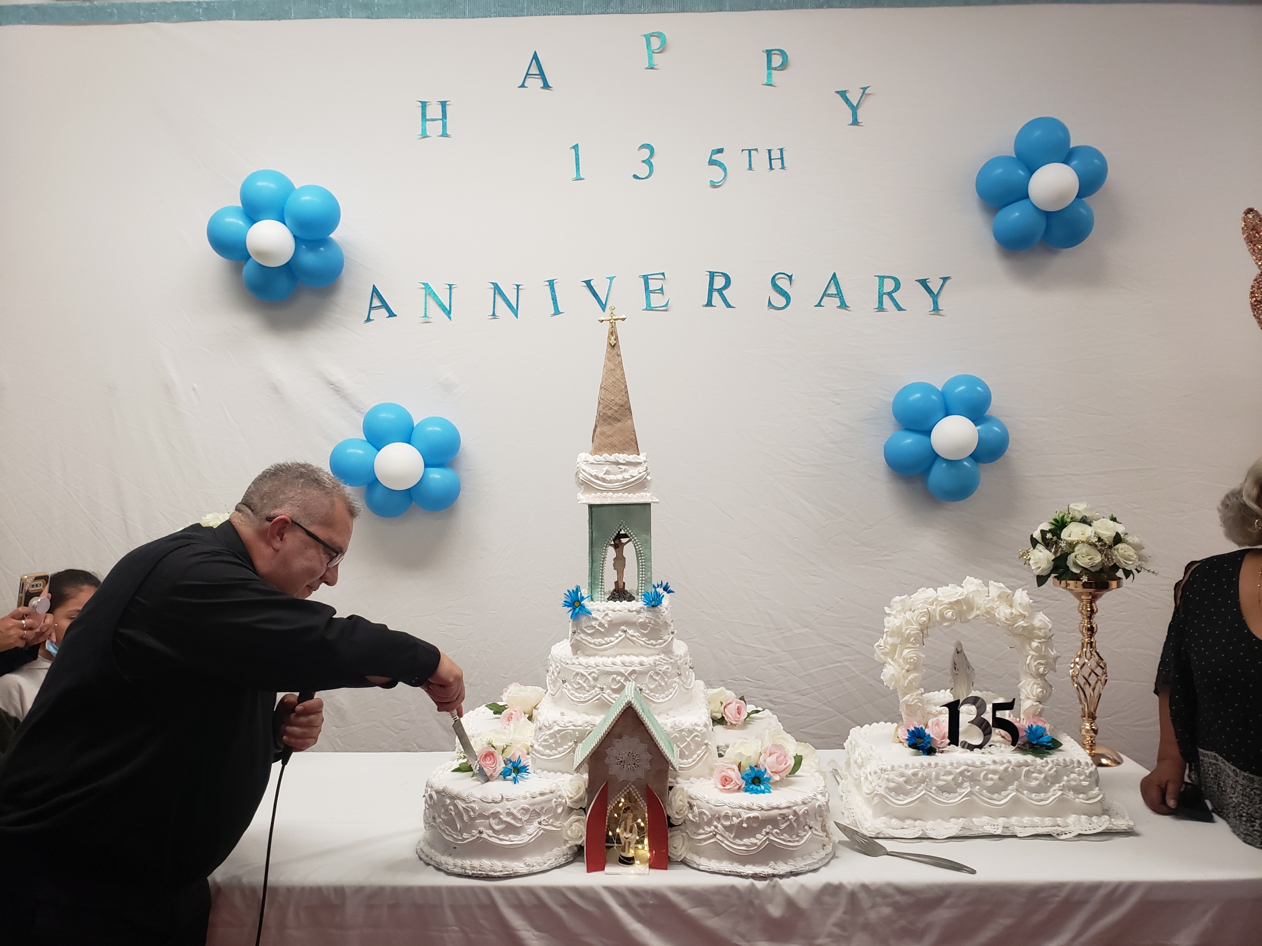 A man cutting a cake on top of a table.